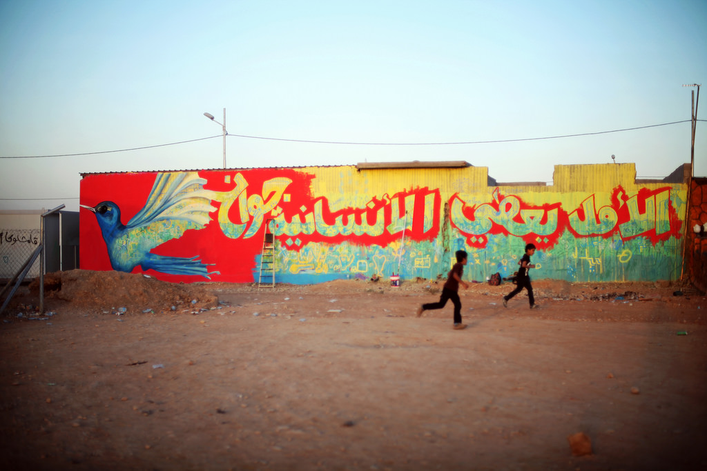 Refugees from the war in Syria continue to arrive to the Kurdistan region of Iraq. Despite the seemingly impossible situation, children created a mural that reads, “hope gives wings to humanity.” Photo by Samantha Robinson, European Commission, public domain