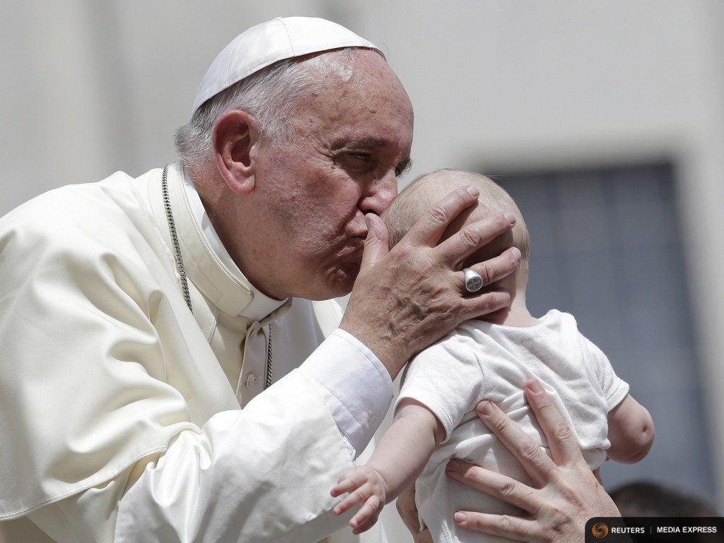 Pope Francis kisses a baby as he leaves at the end of his Wednesday general audience in Saint Peter's square at the Vatican June 17, 2015. REUTERS/Max Rossi -