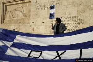 A protester holds a banner in Greek colors in front of the parliament building during an anti-austerity rally in Athens, Greece, June 29, 2015. REUTERS/Yannis Behrakis