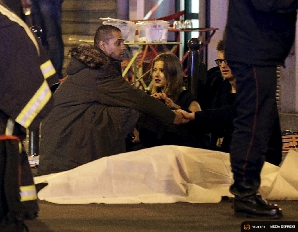 A general view of the scene that shows rescue services personnel working near the covered bodies outside a restaurant following a shooting incident in Paris, France, November 13, 2015.   REUTERS/Philippe Wojazer