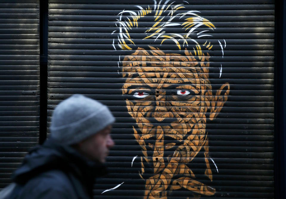 A man walks past a painting of David Bowie of shop sutters in Brixton market, south London, January 11, 2016. REUTERS/Stefan Wermuth