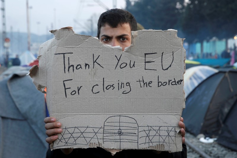 A refguee holds a message, "Thank you EU for closing the border" during a protest asking for the opening of borders at a makeshift camp at the Greek-Macedonian border near the village of Idomeni, Greece, March 18, 2016.   REUTERS/Alkis Konstantinidis