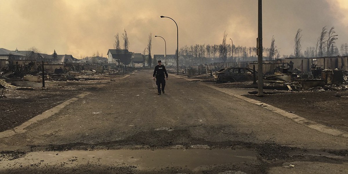 A Mountie surveys the damage on a street in Fort McMurray, Alberta, Canada in this May 4, 2016 image posted on social media. Courtesy Alberta RCMP/Handout via REUTERS