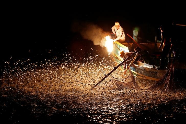 Fishermen use a fire to attract fish on a traditional “sulfuric fire fishing" boat in New Taipei City, Taiwan June 19, 2016. REUTERS/Tyrone Siu