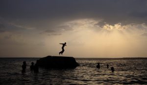 A boy prepares to jump off a rock into the waters of the Osman Sagar Lake near the southern Indian city of Hyderabad May 29, 2011. REUTERS/Krishnendu Halder/File Photo
