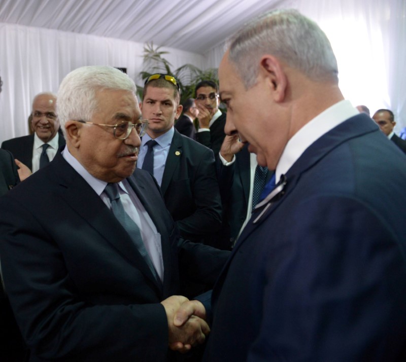 Israeli Prime Minister Benjamin Netanyahu shakes hands with Palestinian President Mahmoud Abbas (L) during the funeral of former Israeli President Shimon Peres in Jerusalem September 30, 2016. Amos Ben Gershom/Government Press Office (GPO)/Handout via REUTERS